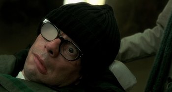 Movie still from “The Diving Bell and the Butterfly” (2007), directed by Julian Schnabel – A man wearing glasses and a black hat; Close Up shot, Overhead angle