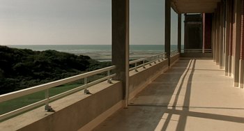 Movie still from “The Diving Bell and the Butterfly” (2007), directed by Julian Schnabel – A view of the ocean from the balcony of a building; Extreme Wide shot, High angle