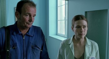 Movie still from “The Diving Bell and the Butterfly” (2007), directed by Julian Schnabel – A man and a woman standing next to each other in front of a window; Close Up shot, Low angle