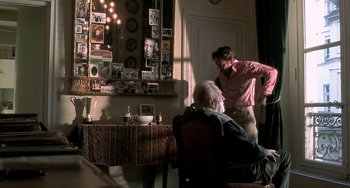 Movie still from “The Diving Bell and the Butterfly” (2007), directed by Julian Schnabel – An older man sitting in front of an older gentleman; Medium shot, Over the shoulder angle
