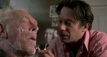 Movie still from “The Diving Bell and the Butterfly” (2007), directed by Julian Schnabel – A man shaving another man's face with a razor; Close Up shot, Over the shoulder angle