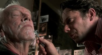 Movie still from “The Diving Bell and the Butterfly” (2007), directed by Julian Schnabel – A man getting his face shaven by a woman; Close Up shot, Low angle
