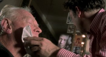 Movie still from “The Diving Bell and the Butterfly” (2007), directed by Julian Schnabel – An older man getting his face waxed by a barber; Close Up shot, Over the shoulder angle