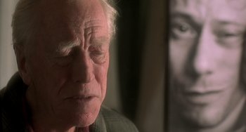 Movie still from “The Diving Bell and the Butterfly” (2007), directed by Julian Schnabel – An older man is looking down at his face; Close Up shot, Over the shoulder angle