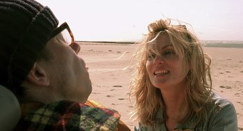 Movie still from “The Diving Bell and the Butterfly” (2007), directed by Julian Schnabel – A woman and a man on the beach looking at each other; Close Up shot, Over the shoulder angle