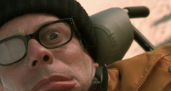 Movie still from “The Diving Bell and the Butterfly” (2007), directed by Julian Schnabel – A person wearing glasses and a hat; Close Up shot, Overhead angle