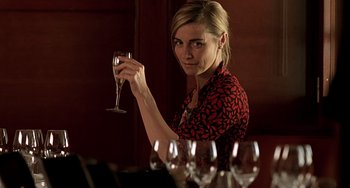 Movie still from “The Diving Bell and the Butterfly” (2007), directed by Julian Schnabel – A woman holding up a wine glass in front of a bunch of wine glasses; Close Up shot, Low angle