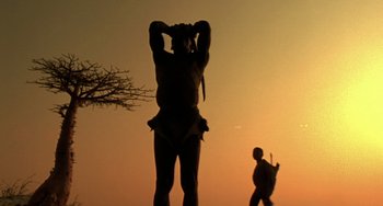 Movie still from “The Diving Bell and the Butterfly” (2007), directed by Julian Schnabel – A man walking in front of an elephant statue; Wide shot, Low angle