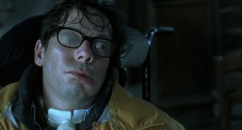 Movie still from “The Diving Bell and the Butterfly” (2007), directed by Julian Schnabel – A person wearing glasses and a yellow jacket; Close Up shot, Overhead angle