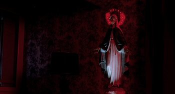 Movie still from “The Diving Bell and the Butterfly” (2007), directed by Julian Schnabel – A statue of the virgin mary is lit up in the dark; Wide shot, Low angle