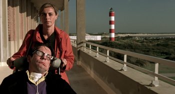 Movie still from “The Diving Bell and the Butterfly” (2007), directed by Julian Schnabel – A man and a woman standing next to each other on a bridge; Medium shot, Low angle