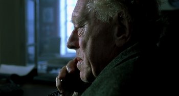 Movie still from “The Diving Bell and the Butterfly” (2007), directed by Julian Schnabel – An older man sitting in front of a window with his hand under his chin; Close Up shot, Low angle