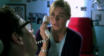 Movie still from “The Diving Bell and the Butterfly” (2007), directed by Julian Schnabel – A woman talking on a phone while sitting down in a room; Close Up shot, Over the shoulder angle