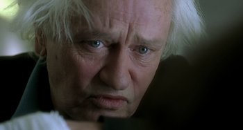 Movie still from “The Diving Bell and the Butterfly” (2007), directed by Julian Schnabel – An old man with white hair and blue eyes looking angry; Close Up shot, Low angle