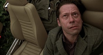 Movie still from “The Diving Bell and the Butterfly” (2007), directed by Julian Schnabel – A man sitting on the floor of a car; Close Up shot, Low angle