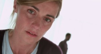 Movie still from “The Diving Bell and the Butterfly” (2007), directed by Julian Schnabel – A woman's face with a man in the background; Close Up shot, Low angle