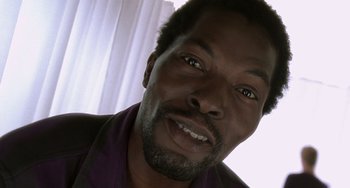 Movie still from “The Diving Bell and the Butterfly” (2007), directed by Julian Schnabel – A man's face in a purple shirt; Close Up shot, Low angle