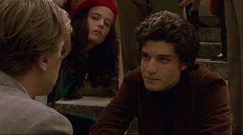 Movie still from “The Dreamers” (2003), directed by Bernardo Bertolucci – A group of young people sitting on the ground; Close Up shot, High angle