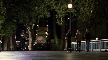 Movie still from “The Dreamers” (2003), directed by Bernardo Bertolucci – Two people standing under a street light at night; Extreme Wide shot, High angle