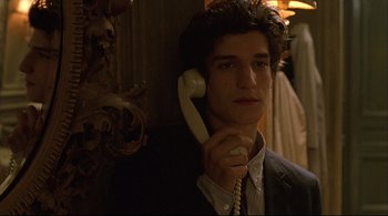 Movie still from “The Dreamers” (2003), directed by Bernardo Bertolucci – A young man holding a phone up to his ear; Close Up shot, Low angle