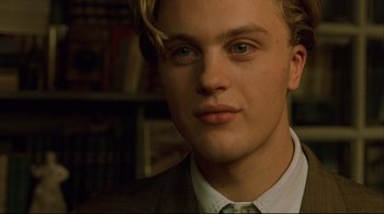 Movie still from “The Dreamers” (2003), directed by Bernardo Bertolucci – A person wearing a suit and tie; Close Up shot, Over the shoulder angle