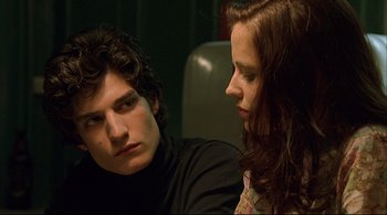 Movie still from “The Dreamers” (2003), directed by Bernardo Bertolucci – A man and a woman sitting next to each other; Close Up shot, Over the shoulder angle