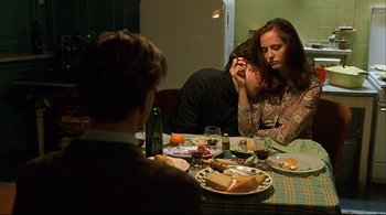 Movie still from “The Dreamers” (2003), directed by Bernardo Bertolucci – A man and a woman sitting at a dinner table; Medium shot, Over the shoulder angle