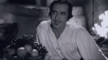 Movie still from “The Dreamers” (2003), directed by Bernardo Bertolucci – A black and white photo of a man holding a bunch of grapes; Close Up shot, High angle