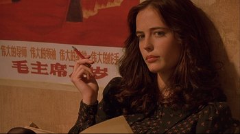 Movie still from “The Dreamers” (2003), directed by Bernardo Bertolucci – A young woman holding a pen in one hand and a cigarette in the other; Close Up shot, Low angle