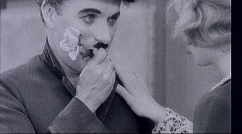 Movie still from “The Dreamers” (2003), directed by Bernardo Bertolucci – An old photo of a woman putting a flower in a man's mouth; Extreme Close Up shot, Low angle