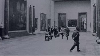 Movie still from “The Dreamers” (2003), directed by Bernardo Bertolucci – A black and white photo of people walking in a museum; Extreme Wide shot, High angle