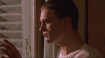 Movie still from “The Dreamers” (2003), directed by Bernardo Bertolucci – A man looking out of a window at the sun; Close Up shot, Low angle