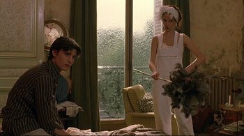 Movie still from “The Dreamers” (2003), directed by Bernardo Bertolucci – A man and a woman in a room with a window behind them; Medium shot, Low angle