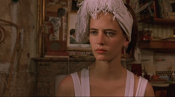 Movie still from “The Dreamers” (2003), directed by Bernardo Bertolucci – A young woman with a feather headband is looking at the camera; Close Up shot, Low angle