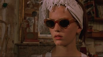 Movie still from “The Dreamers” (2003), directed by Bernardo Bertolucci – A woman wearing a white hat and a pair of sunglasses; Close Up shot, Low angle