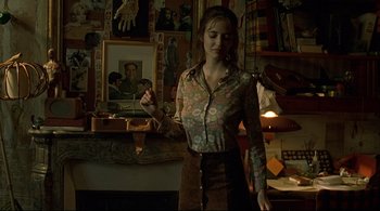 Movie still from “The Dreamers” (2003), directed by Bernardo Bertolucci – A woman standing in front of a wall with pictures on it; Medium shot, Low angle
