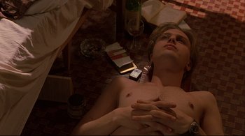 Movie still from “The Dreamers” (2003), directed by Bernardo Bertolucci – A man laying on the ground with his hands on his chest; Medium shot, Overhead angle