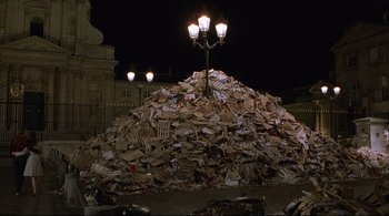 Movie still from “The Dreamers” (2003), directed by Bernardo Bertolucci – A pile of papers on top of a pile of trash; Extreme Wide shot, High angle