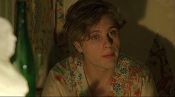 Movie still from “The Dreamers” (2003), directed by Bernardo Bertolucci – A young man in a floral shirt looks at the camera; Close Up shot, Over the shoulder angle