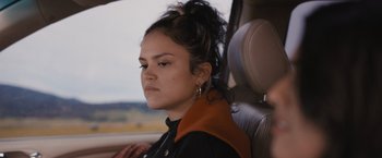 Movie still from “Plan B” (2021), directed by Natalie Morales – A woman sitting in the passenger seat of a car; Close Up shot, Over the shoulder angle