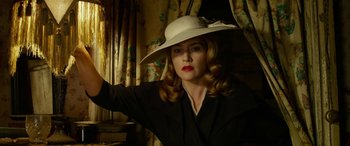 Movie still from “The Dressmaker” (2015), directed by Jocelyn Moorhouse – A woman in a white hat and a black suit; Medium shot, Low angle