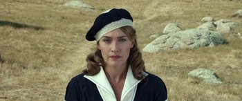 Movie still from “The Dressmaker” (2015), directed by Jocelyn Moorhouse – A woman wearing a black and white hat in a field; Close Up shot, Low angle