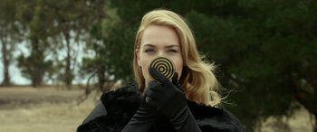 Movie still from “The Dressmaker” (2015), directed by Jocelyn Moorhouse – A woman wearing black gloves and holding an object in front of her face; Close Up shot, Over the shoulder angle