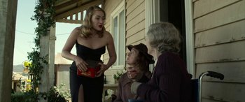 Movie still from “The Dressmaker” (2015), directed by Jocelyn Moorhouse – A woman in a black dress talking to two older people; Medium shot, Over the shoulder angle