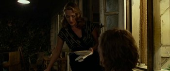 Movie still from “The Dressmaker” (2015), directed by Jocelyn Moorhouse – A woman is holding a plate of food in her hand; Medium shot, Over the shoulder angle