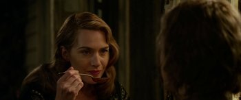 Movie still from “The Dressmaker” (2015), directed by Jocelyn Moorhouse – A woman looking in the mirror while holding a spoon; Close Up shot, Over the shoulder angle