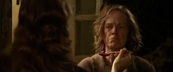 Movie still from “The Dressmaker” (2015), directed by Jocelyn Moorhouse – An older woman looking in the mirror holding a spoon; Close Up shot, Over the shoulder angle
