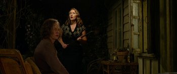 Movie still from “The Dressmaker” (2015), directed by Jocelyn Moorhouse – A woman is holding a cane and a woman is sitting on a chair; Medium shot, Low angle