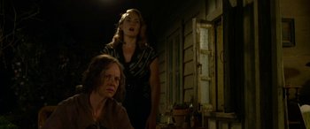 Movie still from “The Dressmaker” (2015), directed by Jocelyn Moorhouse – Two women standing next to each other in front of a building; Medium shot, Low angle