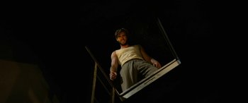 Movie still from “The Dressmaker” (2015), directed by Jocelyn Moorhouse – A man standing on top of a stair case; Medium shot, Overhead angle